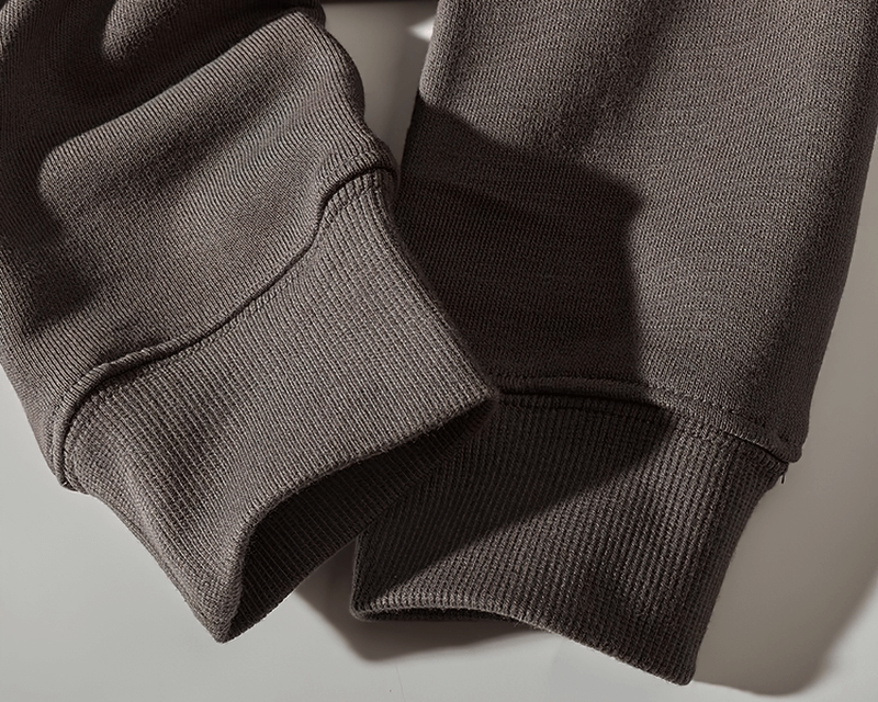 Close-up of solid color warm kangaroo pocket sweatshirt cuffs, perfect for casual winter wear.